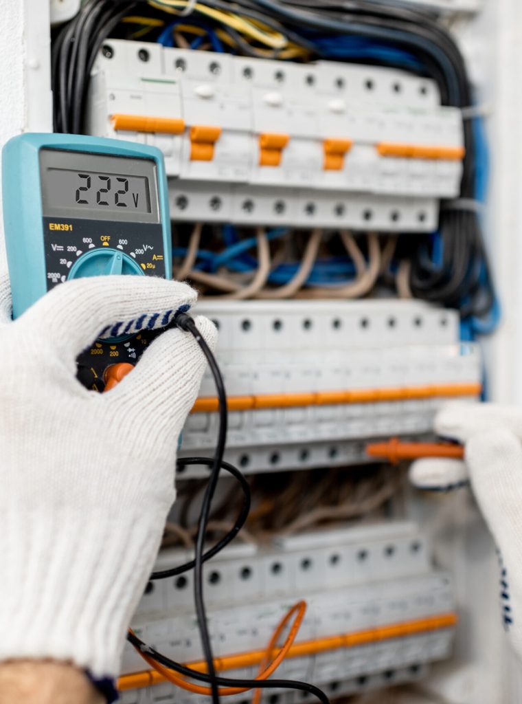 Electrician installing or repairing apartment electrical panel, close-up view